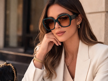 Marciano by Guess emerald green oversized sunglasses worn by model in white blazer | Grae Collection