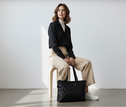 Model seated with NBM Quilted Tote Bag — editorial lifestyle shot
